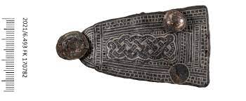 Ngoài chiếc ghim cài vàng, địa vị xã hội của người phụ nữ còn được thể hiện qua những món trang sức khác ở phần thân trên, gồm 160 viên ngọc trai, hạt thủy tinh, thạch anh tím và hổ phách, tất cả đều đính vào chiếc áo choàng giờ đã biến mất.