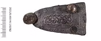 Ngoài chiếc ghim cài vàng, địa vị xã hội của người phụ nữ còn được thể hiện qua những món trang sức khác ở phần thân trên, gồm 160 viên ngọc trai, hạt thủy tinh, thạch anh tím và hổ phách, tất cả đều đính vào chiếc áo choàng giờ đã biến mất.