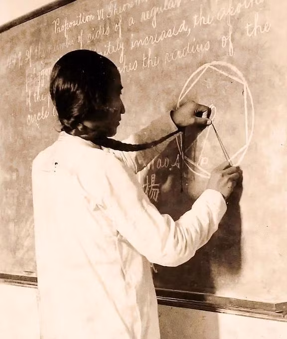  Bức ảnh chụp một học sinh của Đại học đường Kinh Sư đang tận dụng bím tóc vẽ đường tròn trong môn toán hình học. Trên bảng đen là một loạt chữ tiếng Anh. Có thể thấy, giáo dục phương Tây đang được phổ cập rộng rãi và được tiếp thu một cách tích cực.