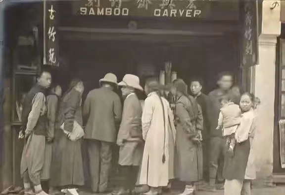 Là một đô thị hóa quốc tế, đường phố Thượng Hải đương nhiên không thiếu người nước ngoài. Khách khứa, có người Trung Quốc lẫn người phương Tây, đang vây xem tác phẩm tranh khắc trúc. Biển hiệu cửa hàng có dòng chữ tiếng Anh: Bamboo Carver (điêu khắc trên trúc).