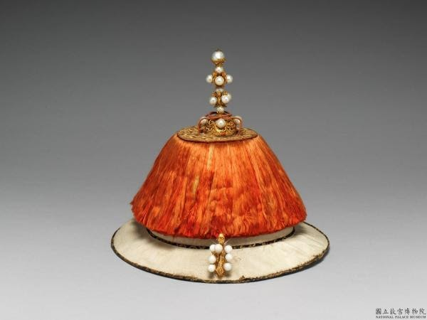 Sau khi nhà Thanh tiến vào Trung Nguyên, làm chủ giang sơn, các Hoàng đế đã có quy định rõ ràng về triều quan: “Trên đỉnh đính chu vĩ (phần lông mềm và bông xù màu đỏ), phía trước xuyết tượng kim Phật, điểm xuyết mười lăm viên đông châu” (đông châu là một loại trân châu chỉ có tại vùng nước ngọt tại Đông Bắc).