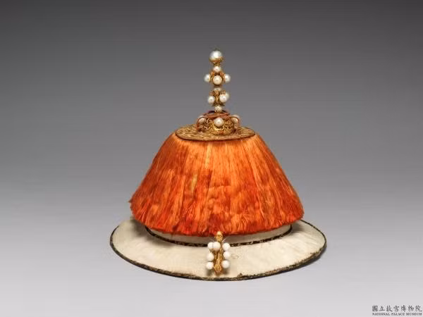 Sau khi nhà Thanh tiến vào Trung Nguyên, làm chủ giang sơn, các Hoàng đế đã có quy định rõ ràng về triều quan: “Trên đỉnh đính chu vĩ (phần lông mềm và bông xù màu đỏ), phía trước xuyết tượng kim Phật, điểm xuyết mười lăm viên đông châu” (đông châu là một loại trân châu chỉ có tại vùng nước ngọt tại Đông Bắc).