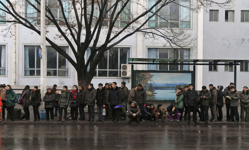 Nhiều người dân đứng chờ xe bus trên một tuyến phố ở Bình Nhưỡng.