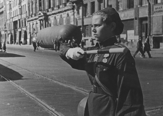 Từ tháng 9/1941 - 1/1944, Quân đội Đức quốc xã theo lệnh của trùm phát xít Hitler đã thực hiện cuộc tấn công, vây hãm thành phố Leningrad của Liên Xô. Cuộc vây hãm Leningrad kéo dài 900 ngày. Trong khoảng thời gian đó, quân và dân Liên Xô kiên cường chiến đấu, bảo vệ lãnh thổ, quyết không đầu hàng kẻ địch. Trong ảnh là một bóng hồng làm nhiệm vụ điều tiết giao thông ở Leningrad.