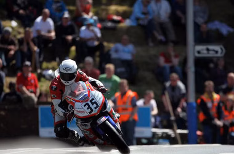 Giải đua Isle of Man dành cho xe hai bánh kéo dài một tuần, bao gồm nhiều thể loại và đỉnh điểm là vòng đua cấp cao TT Senior vào ngày đua cuối. Đây là một giải đua tính giờ bắt đầu từ năm 1907, được tổ chức trên đảo Isle of Man nằm ngoài khơi biển Ai-len, giữa Anh và Ireland. Đường đua băng qua những làng mạc với tường đá và cây.