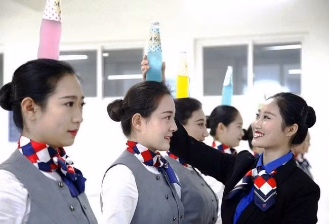 Bài tập quan trọng nhất để có dáng đứng chuẩn là giữ thăng bằng. Các nữ học viên phải làm sao cho chai thủy tinh trên đầu không rơi trong vòng 3 phút. Ảnh: Protothema.