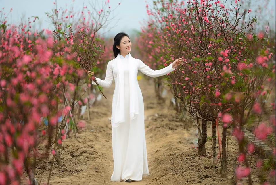 Bối cảnh được lựa chọn để chụp các bộ ảnh Tết cũng khá đa dạng, tuy nhiên cũng có một vài nơi đặc biệt phù hợp và dường như cứ hễ nhắc đến chụp ảnh Tết là các bạn trẻ lại nghĩ đến ngay lập tức. Nếu ở Hà Nội, miền Bắc, những vườn hoa đào ở Nhật Tân, những làng hoa ven đê sông Hồng... luôn là một địa điểm hút khách trẻ tuổi mỗi dịp Tết đến chụp ảnh... Ảnh: Lê Xuân Bách.