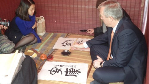 Vừa viết, ngài đại sứ vừa nghe thầy Lược giải thích về ý nghĩa của chữ, cũng như cách thể hiện các nét bút.