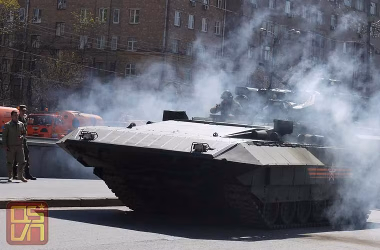 Không chỉ T-14 Armata, xe chiến đấu bộ binh T-15 Armata cũng mắc lỗi máy tương tự ngay trước cổng…Đại sứ quán Mỹ. Trong ảnh, kíp lái T-15 Armata nhấn ga xả khói mù mịt cũng không khiến cỗ xe khổng lồ nhúc nhích. Rõ ràng, nhà sản xuất Uralvagonzavod còn rất nhiều việc phải làm với khung gầm Armata.