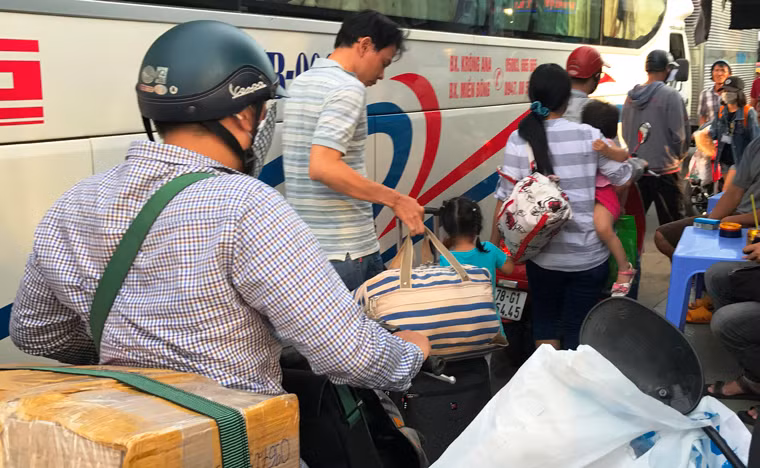 Người dân lỉnh kỉnh hành lý, tay xách, nách mang...đưa nhau ra bến xe để về quê.