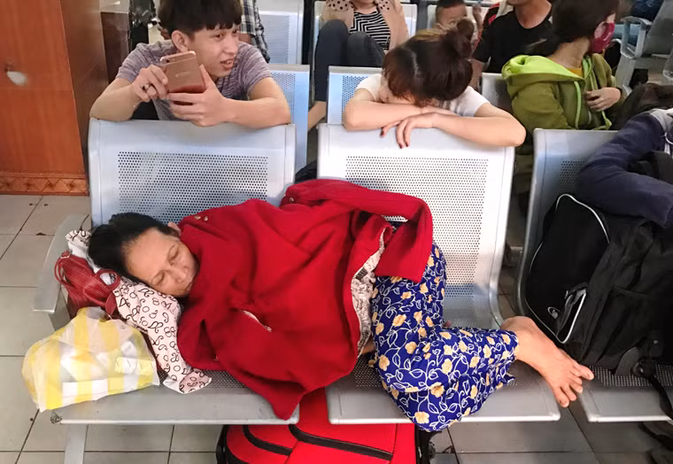 Người phụ nữ quê 1 tỉnh phía Bắc rã rời tìm giấc ngủ vội tại bến xe trong lúc chờ giờ khởi hành về quê vào tối 28/4.