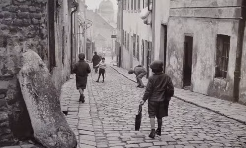 Một nhóm trẻ em Do Thái chơi đùa trên con đường lát gạch.