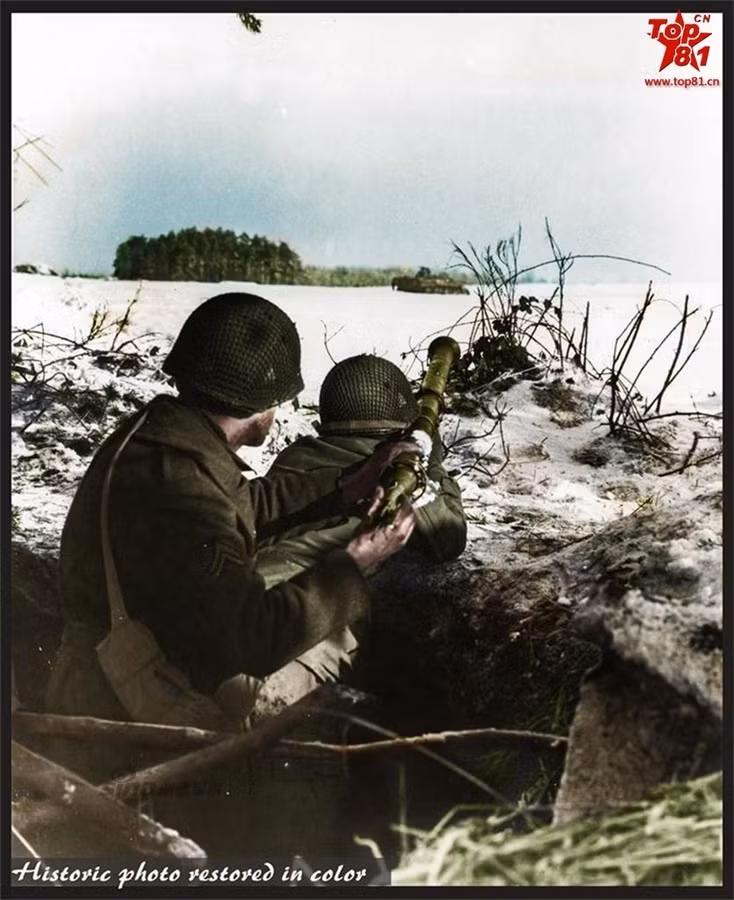 Một người lính Mỹ đang nạp đạn cho khẩu súng chống tăng Bazoka trên vai đồng đội ngắm bắn mục tiêu quân phát xít trên chiến trường châu Âu.