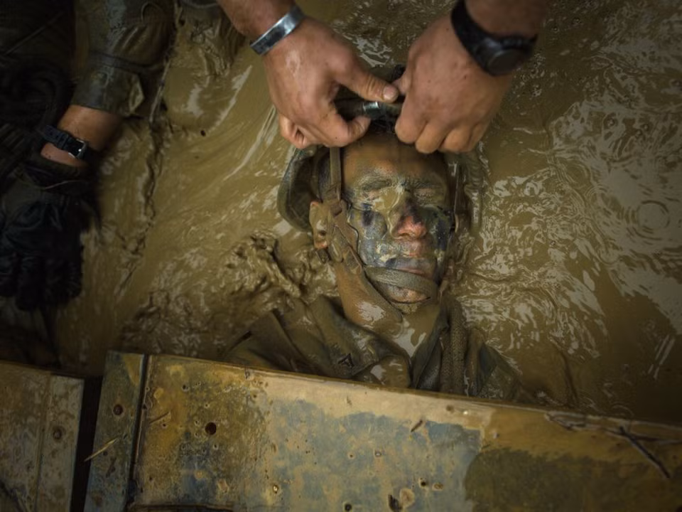 Một binh lính Thủy quân Lục chiến Mỹ được đồng đội lôi ra khỏi một hố bùn trong tình trạng không thể thê thảm hơn. Nguồn ảnh: BI.