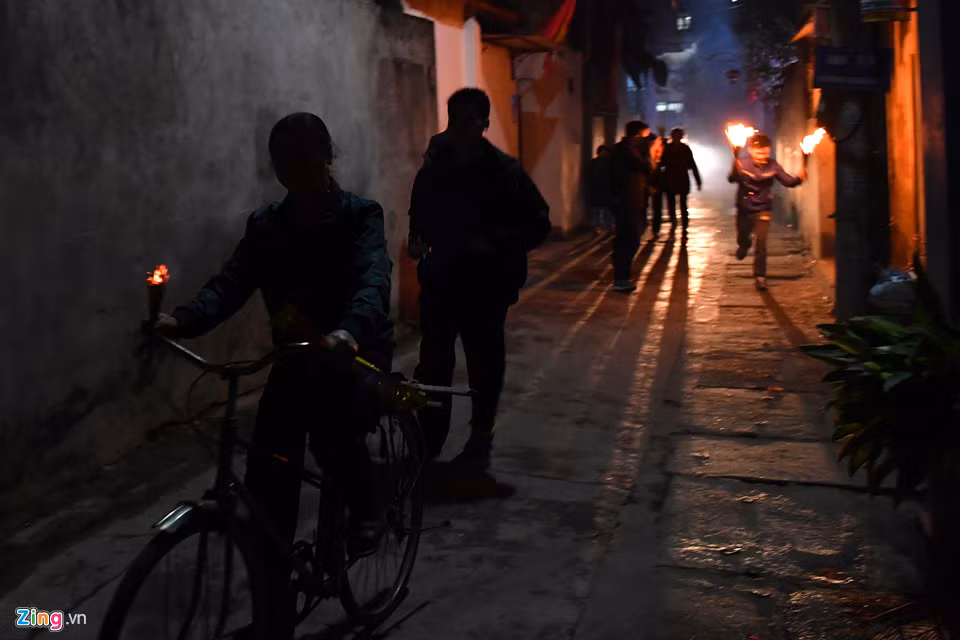 Dọc các ngõ phố của làng An Định rộn rã tiếng cười vui, "chạy lửa", nhiều người còn dùng xe đạp cho nhanh.