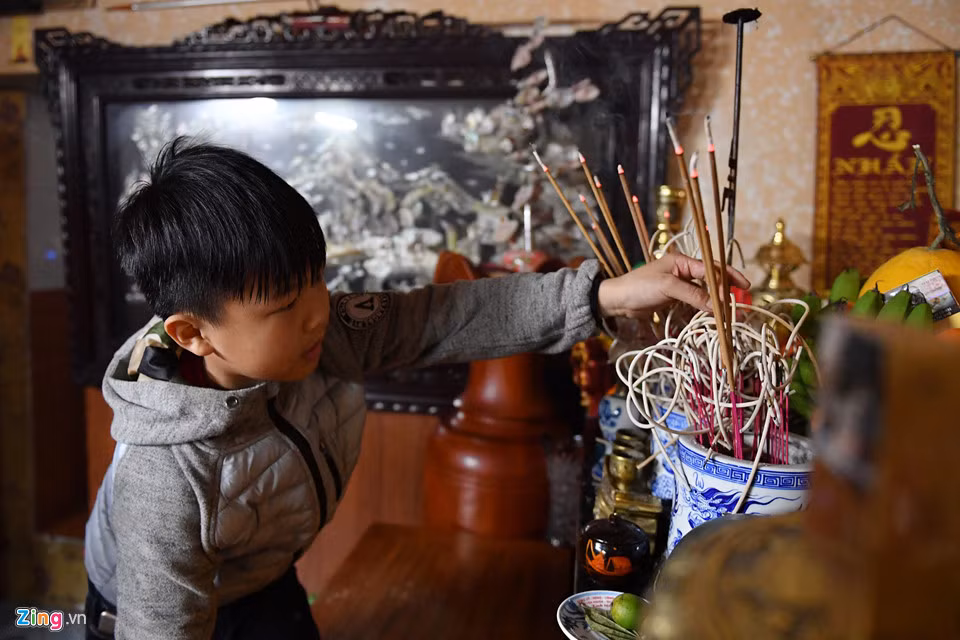 Sau khi về tới nhà, cậu bé dành 3 nén hương thắp lên ban thờ tổ tiên của gia đình. Những năm trước đây khi còn nhỏ, Anh Quân thường được theo ông và bố đi lấy đỏ.