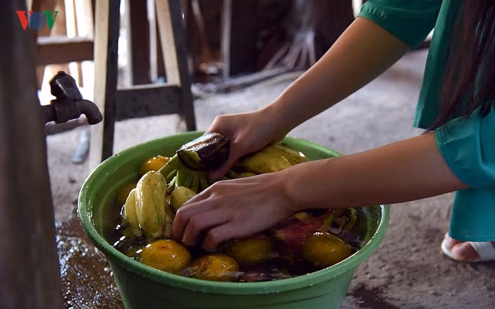 Trong khi các bà các mẹ nấu bếp, con cháu cũng tranh thủ rửa hoa quả để bày mâm ngũ quả trên bàn thờ tổ tiên.