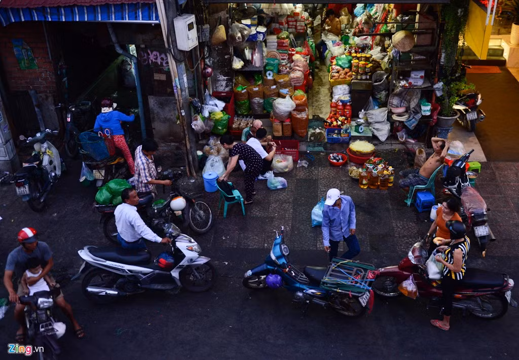 Dưới chân cầu Ông Lãnh trên đường Nguyễn Thái Học, tiểu thương buôn bán ngay trên vỉa hè, nhiều xe máy đậu tràn ra đường.