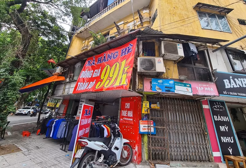 Một cửa hàng vừa treo thông báo xả hàng, vừa treo luôn biển cho thuê nhà.