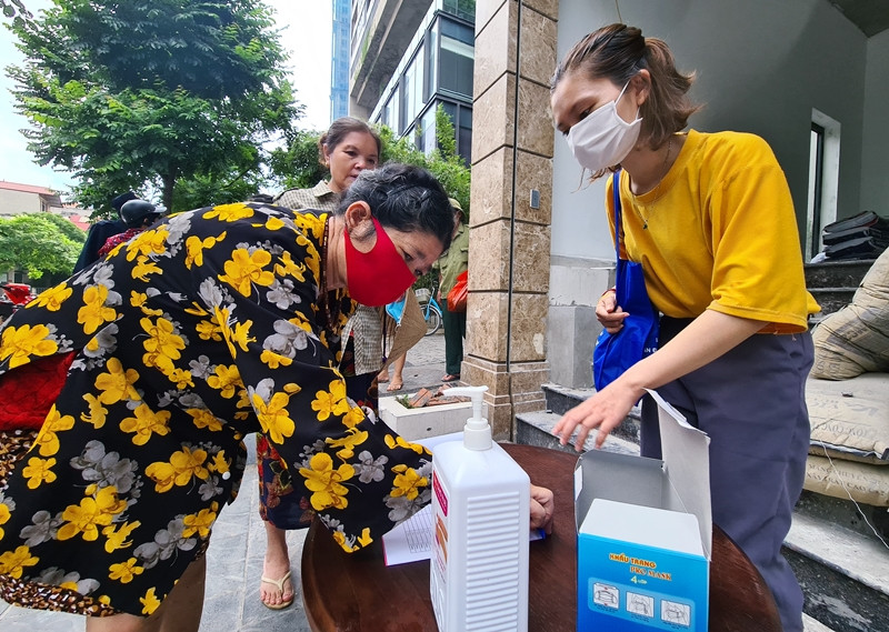 Người dân đều tuân thủ việc khai báo y tế, sát khuẩn tay theo yêu cầu của ban tổ chức nhằm hạn chế việc lây lan dịch bệnh COVID-19 trước khi nhận gạo.