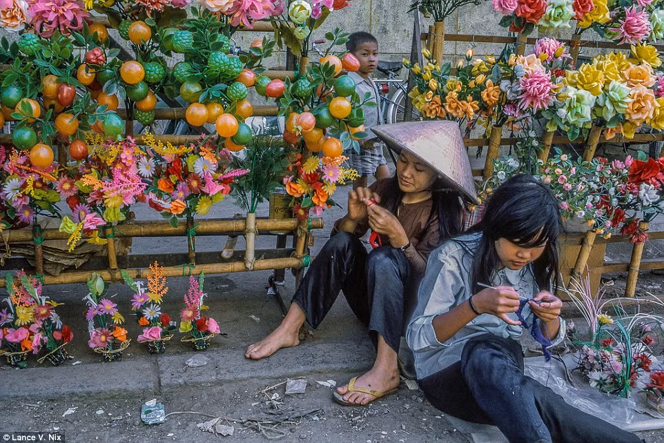 Hai bé gái tỉ mỉ làm những bông hoa giả để bán. Ảnh chụp tại Mỹ Tho năm 1969.