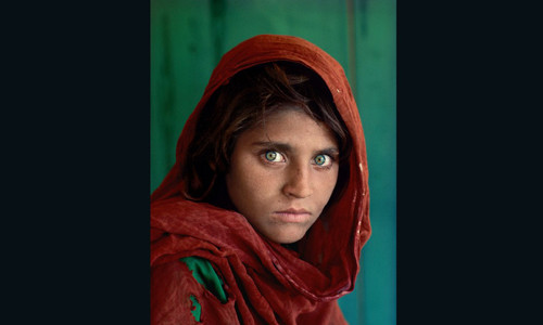 Hình ảnh ám ảnh "cô bé Afghan" trong bức ảnh “Cô gái Afghanistan” của nhiếp ảnh gia Steve McCurry khiến thế giới vừa ngỡ ngàng vừa xúc động. Ông McCurry chụp bức ảnh này năm 1984 tại một trại tị nạn nằm ở miền Tây Bắc Pakistan. Cô bé trong bức ảnh có tên Sharbat Gula có đôi mắt màu xanh biếc. Tấm ảnh này được đăng trên trang bìa số ra tháng 6/1985 của tạp chí du lịch - khám phá nổi tiếng nhất nước Mỹ - National Geographic và trở thành một trong những bức ảnh nổi tiếng nhất lịch sử báo chí.