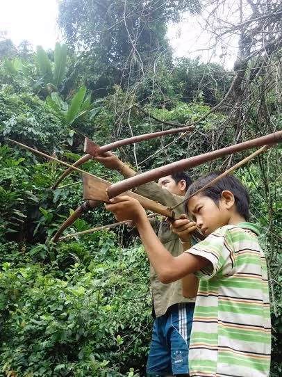 Anh A. Mươi và con trai A. Phăng đang dùng nỏ bắn chuột phá hoại mùa màng.