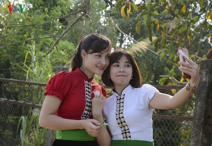 Du khách thích thú khi tạo dáng chụp hình cùng với hoa ban.