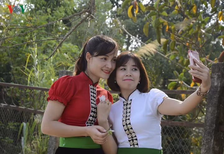 Du khách thích thú khi tạo dáng chụp hình cùng với hoa ban.