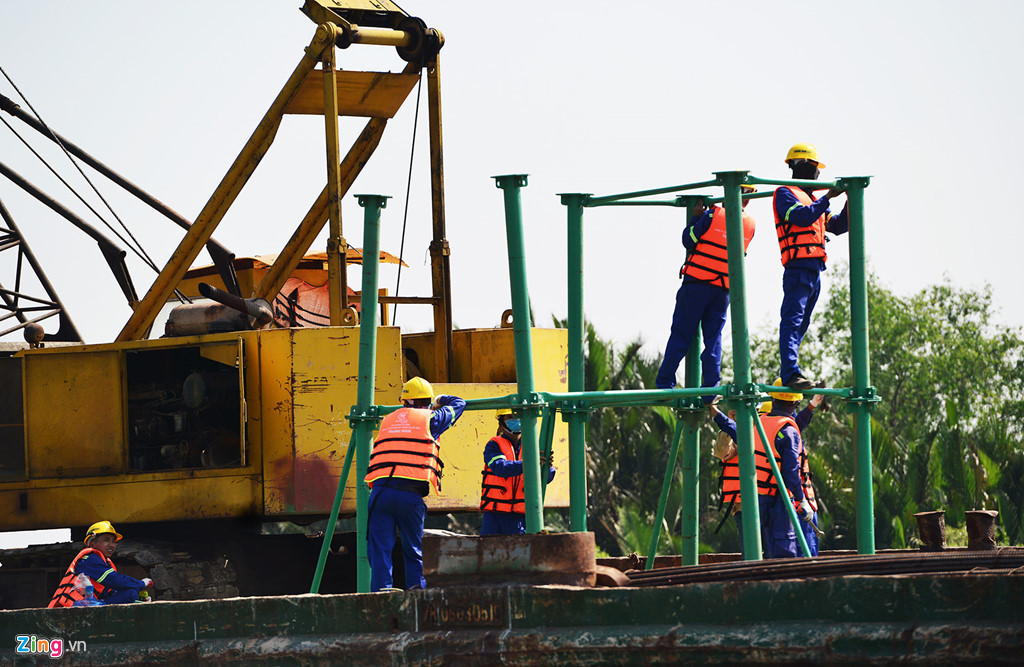 Các công nhân lắp các khung sắt trên sà lan để chuẩn bị thi công các hạng mục cống Cây Khô vào ngày 27/2. Theo chủ đầu tư, các cống Mương Chuối, Phú Xuân, Cây Khô sẽ hoàn thành vào tháng 10 tới. 7 km đê kè ven sông đang được công nhân đẩy nhanh tiến độ, bơm cát gia cố và hoàn thiện trong 2-3 tháng tới.