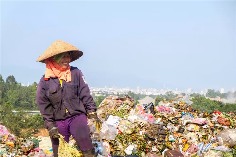 Nụ cười của một phụ nữ khi mưu sinh ở bãi rác Khánh Sơn. 