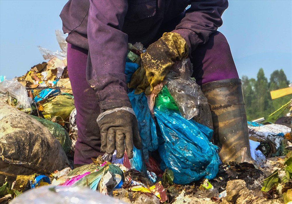 Cũng như bà Thanh, hàng chục phụ nữ khác chỉ Với hành trang là đôi ủng, nón, khẩu trang, bao tời và một cây cuốc chĩa, cứ thế lại lam lũ cày xới, mưu sinh trên bãi rác khổng lồ.