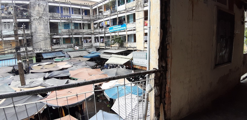 Bên dưới chung cư chờ sập là một khu chợ đang hoạt động nhộn nhịp.