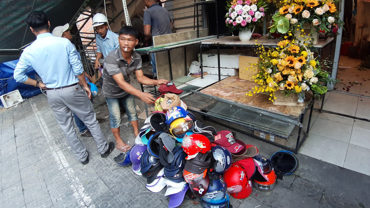 Tại hiện trường sập nhà ở Đà Nẵng, hàng tấn hàng hóa là mũ bảo hiểu để bên trong nhà bị hư hại và vùi lấp trong khối bê tông bị vỡ.