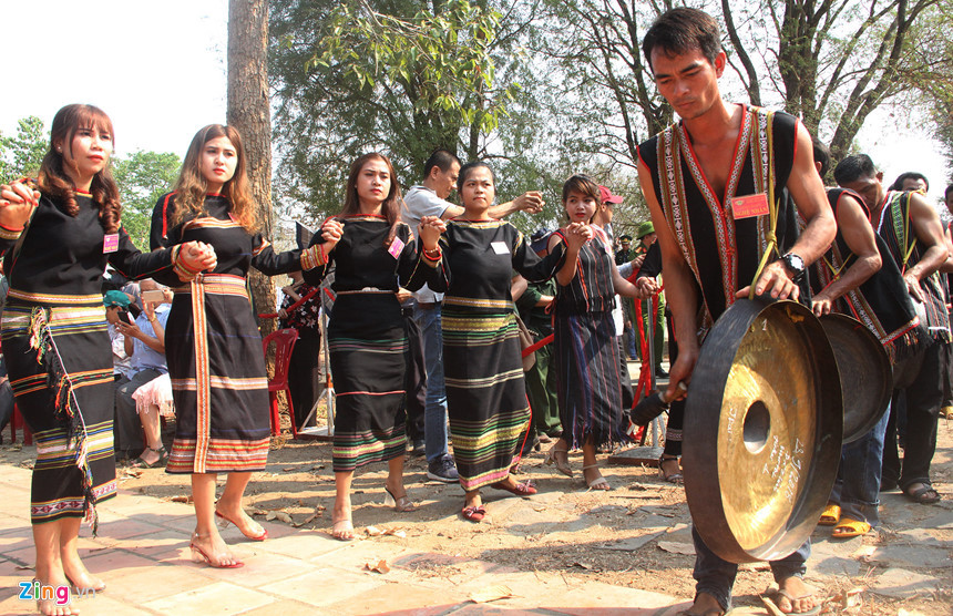 Các trai gái trong làng mặc những trang phục truyền thống nhảy múa bên tiếng cồng chiêng.