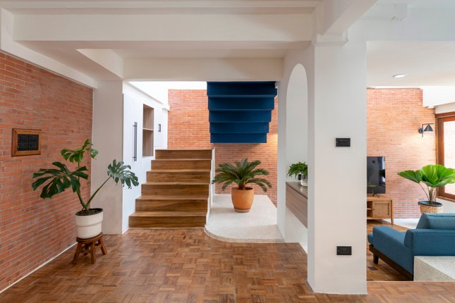 Cầu thang cạnh giếng trời được giữ sạch sẽ và tối giản nhất có thể để không cản trở ánh sáng tự nhiên, đồng thời việc bổ sung các màu sơn xanh ở đây tạo ra chiều sâu và mang lại cho ngôi nhà một cái nhìn độc đáo.