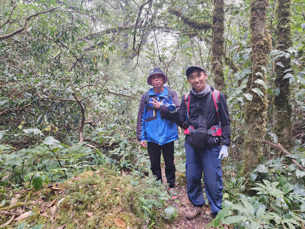 Trưởng bản Sì Thâu Chải bên trái cùng Lù A Pao - Porter bên phải kể cho chúng tôi nghe về những loài cây bên đường đồng thời dẫn đường và mang đồ, giúp chúng tôi không phải mang quá nặng. Tuy nhiên cả đoàn ai cũng mệt.