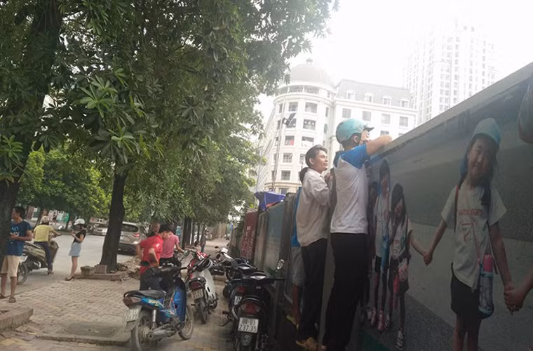 Người dân hiếu kỳ đứng tập trung bên tường bao công trình.