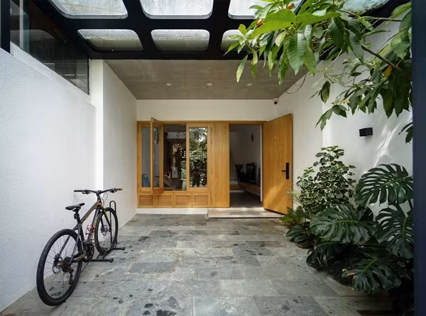 Vì vậy, kiến trúc sư chọn phương án thiết kế mở, phân luồng hợp lý giữa các không gian chức năng, bổ sung nhiều mảng cây xanh len lỏi khắp căn nhà. Ảnh: ECONS Vietnam