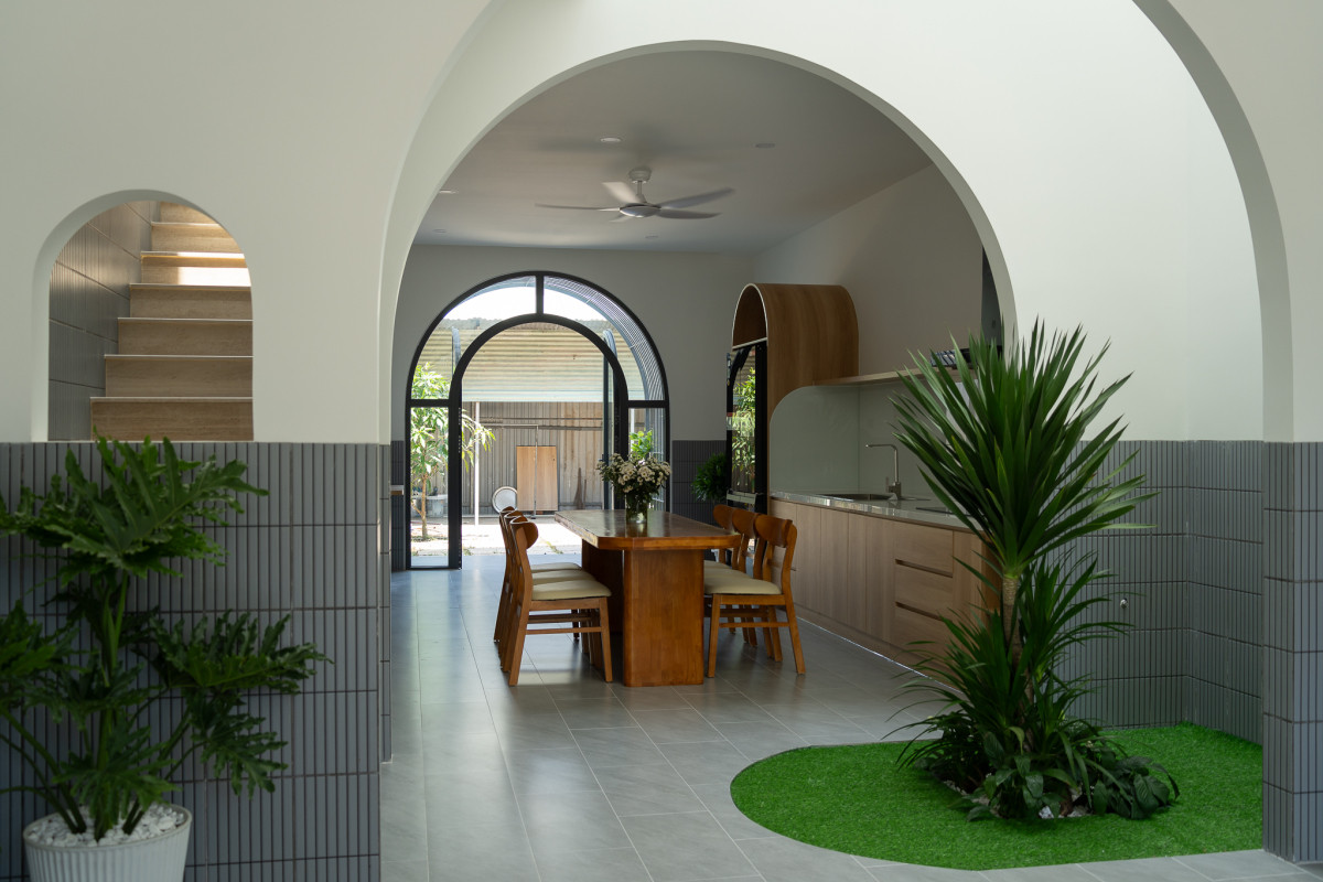 Sân vườn nhỏ ngăn chia phòng khách và bếp - ăn, tạo cảm giác riêng tư cho mỗi không gian. Ảnh: Quang Trần