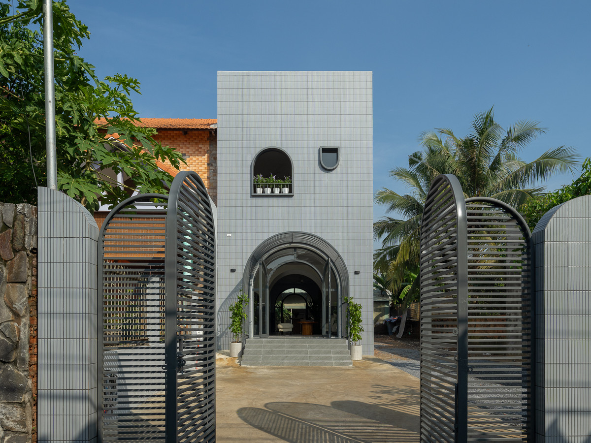 Mặt đứng trước và sau không bố trí ban công nhằm tiết kiệm diện tích, thay vào đó là phần sảnh đón với mái che hình vòm cong, hai bên vòm có trồng cây leo uốn theo. Ảnh: Quang Trần