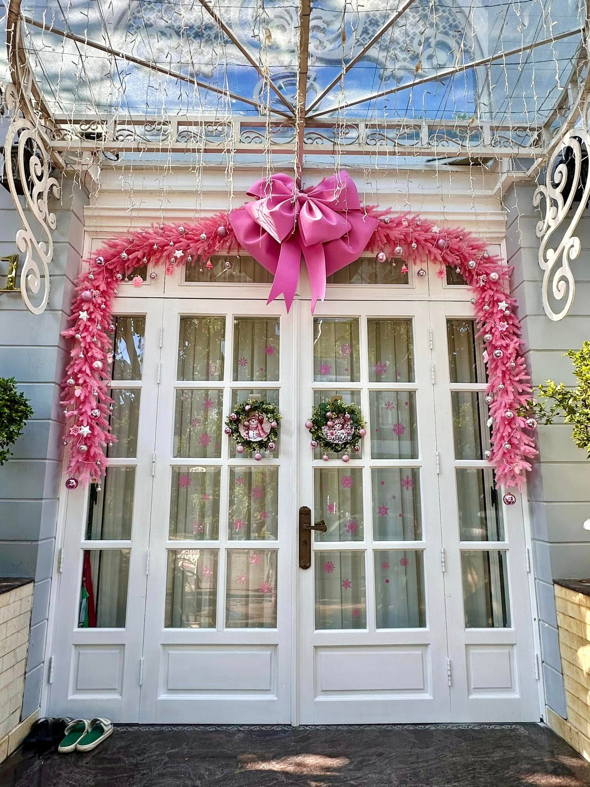 Cửa trắng được tô điểm bởi vòng hoa Giáng sinh màu hồng và đèn LED lung linh. Ảnh: FB Bui Thuy Hanh
