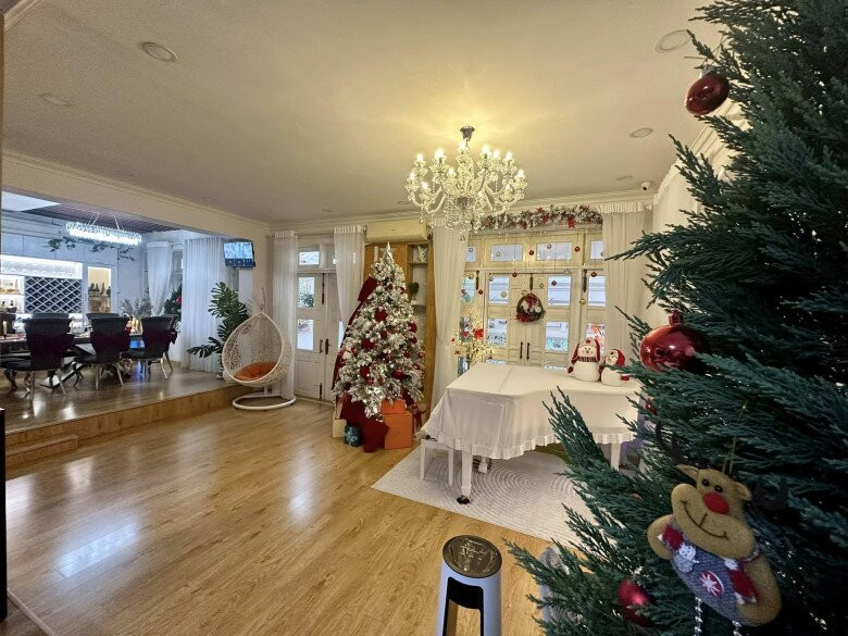 Phòng khách rộng rãi với bộ sofa trắng trang nhã và đèn chùm pha lê nổi bật. Ảnh: FB Vy Oanh