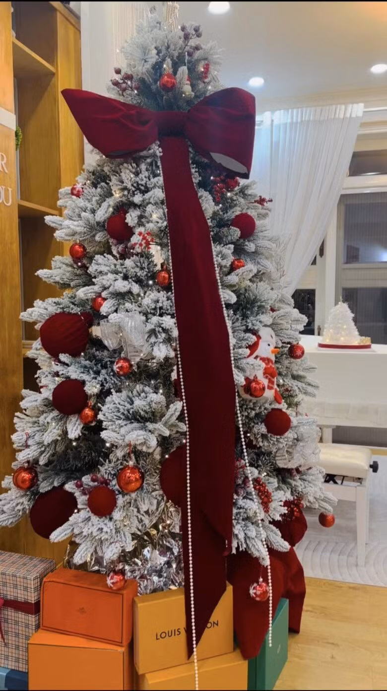 Cây thông còn được trang trí cầu kỳ bằng nơ lụa lớn và dây kim tuyến bạc. Phía dưới là các hộp quà hàng hiệu. Ảnh: FB Vy Oanh