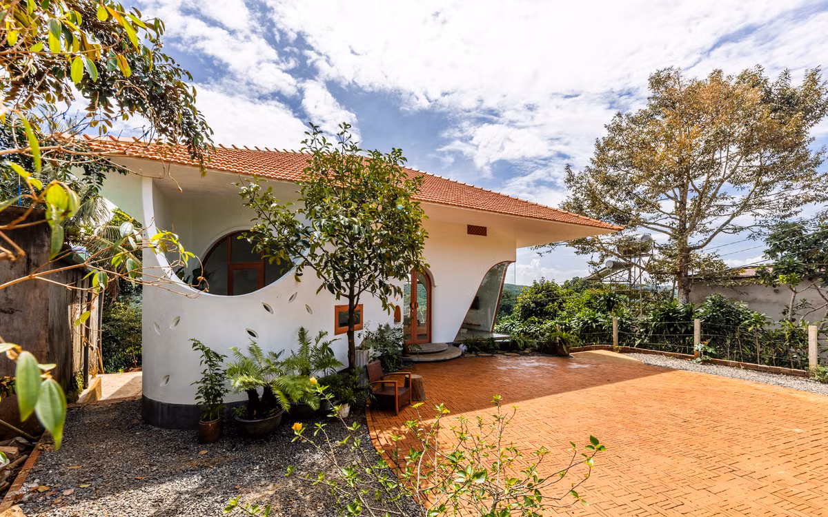 Những đường cong mềm mại của mái nhà, cửa chính, cửa sổ và các họa tiết trang trí trên tường tạo sự liền mạch, gợi lên cảm giác nhẹ nhàng và ấm áp, như một bông hoa nở giữa thiên nhiên. Ảnh: Oki Hiroyuki