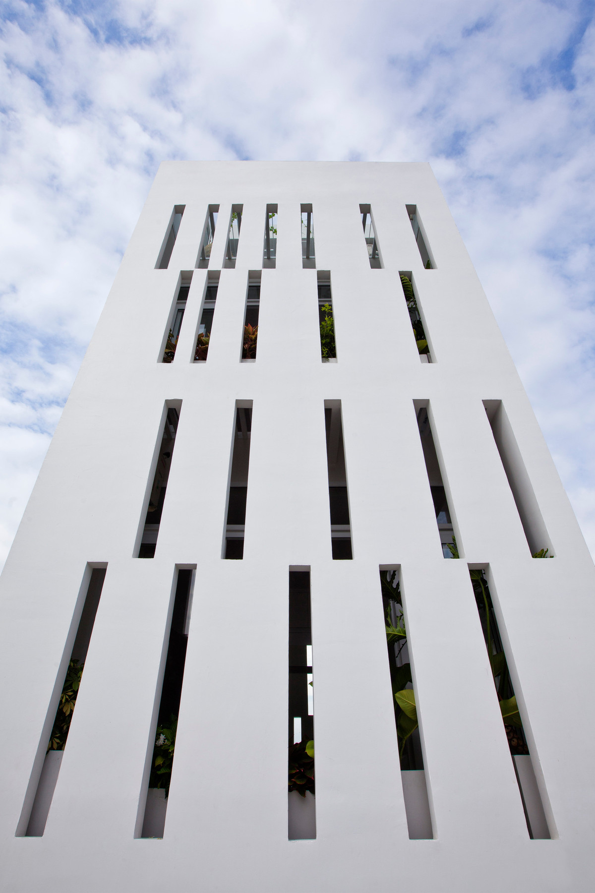 Giải pháp đưa ra là xây bức tường thiết kế những khe thông thoáng với chiều rộng 13cm để sử dụng làm vỏ bao bọc và ngăn chia không gian theo nhu cầu sử dụng của các thành viên trong nhà. Ảnh: Hiroyuki Oki