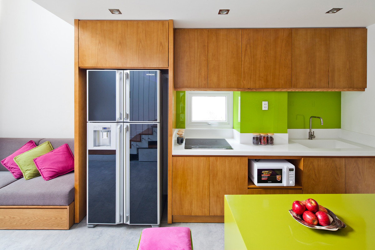 Tường bếp màu xanh và hệ tủ màu nâu vừa tạo cảm giác trái ngược, vừa trung hòa lẫn nhau. Ảnh: Hiroyuki Oki