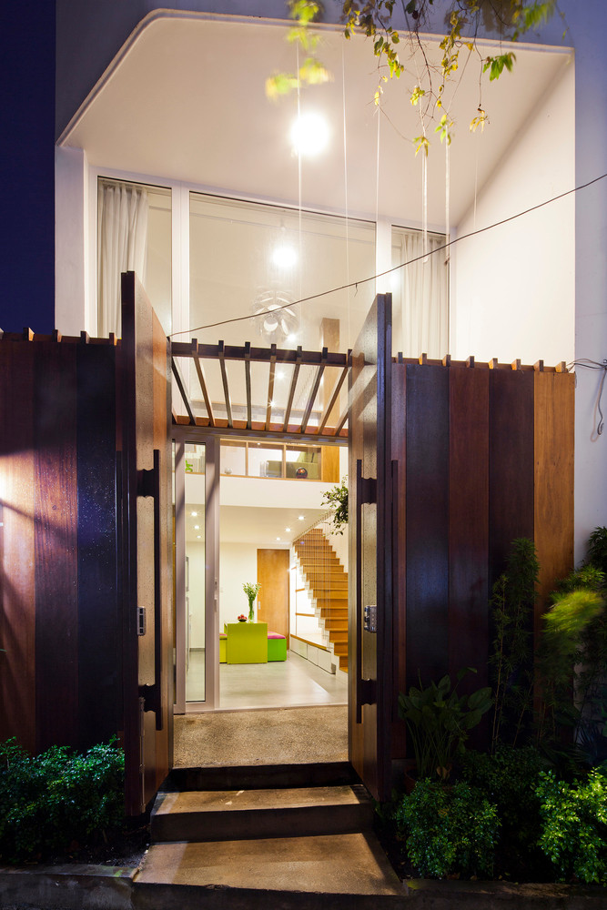 Cửa gỗ độc đáo với nhiều màu nâu khác nhau. Trước cửa có thêm khoảng không để trồng cây xanh. Ảnh: Hiroyuki Oki