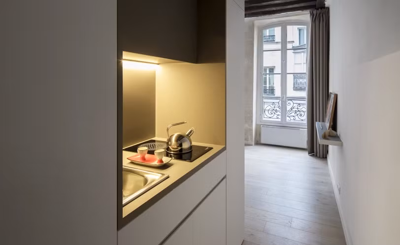 Bếp nhỏ nằm gọn trong một hốc nhỏ có bồn rửa, bếp điện và tủ, được trang bị ngăn kéo, tủ lạnh. Ảnh: Designboom