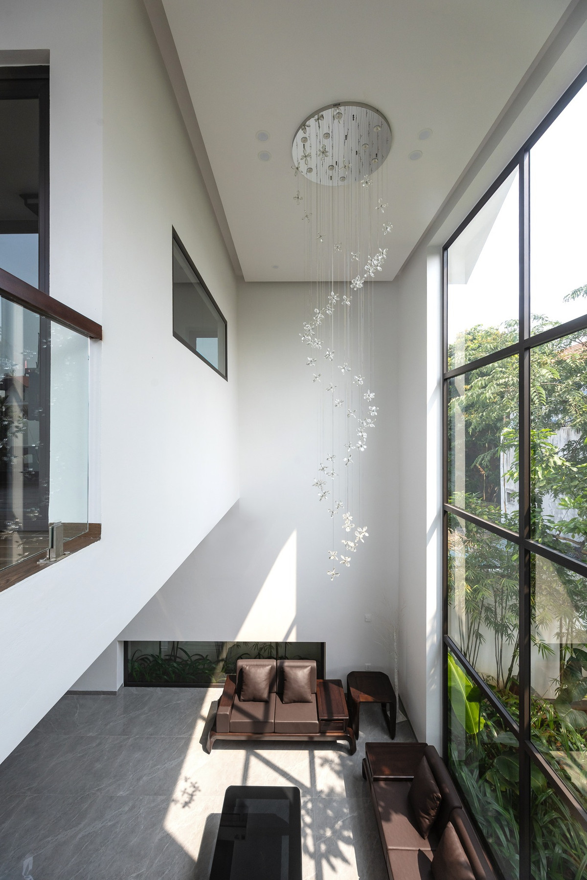 Phòng khách có thiết kế khoảng thông tầng nhằm tăng góc nhìn theo chiều cao cũng như tăng góc nhìn cây xanh trong không gian. Ảnh: Triệu Chiến